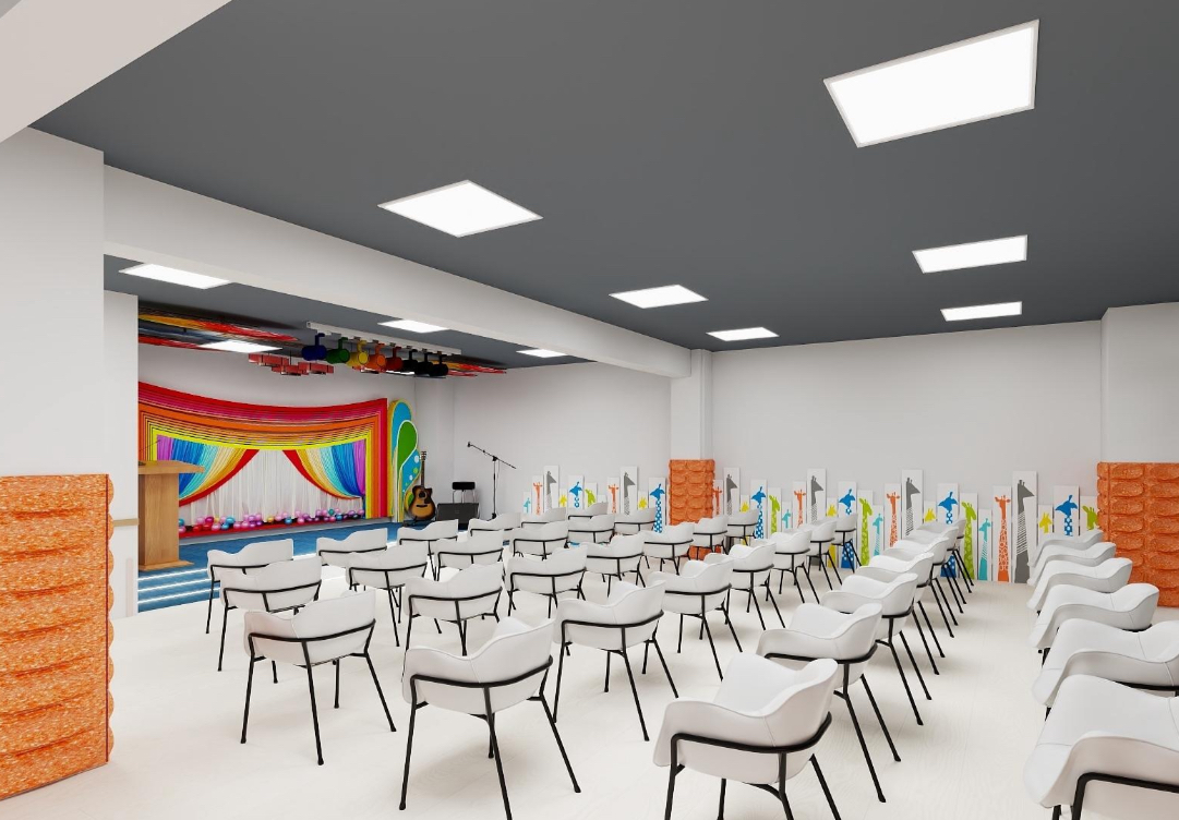 Performance auditorium with stage and white chairs